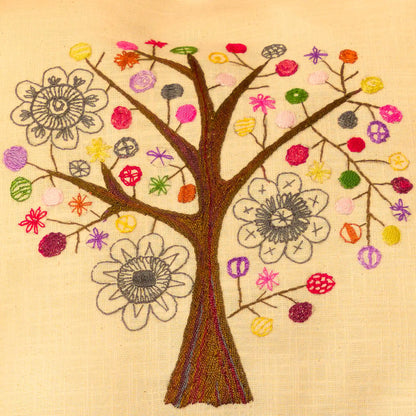 Détail des branches et fleurs d'un arbre brodé en couleurs vive sur une housse de coussin