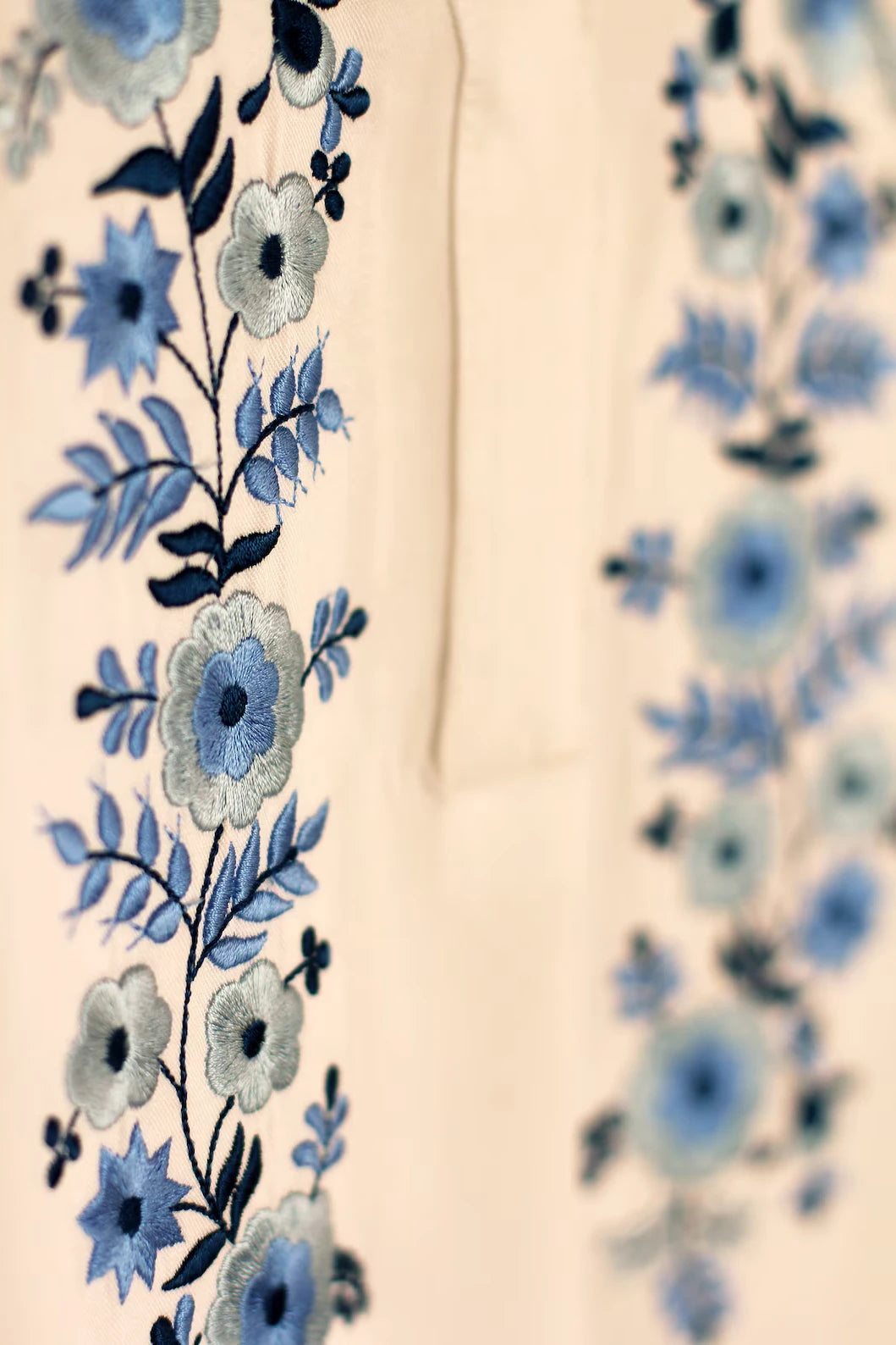 Détail de la broderie de la blouse blanche. les tons bleus et gris argentés s'accordent parfaitement pour ce haut brodé dans la plus pure tradition hongroise.