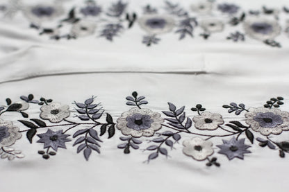 Détail de la broderie de la blouse blanche. les tons blancs et gris argentés s'accordent parfaitement pour ce haut brodé dans la plus pure tradition hongroise.