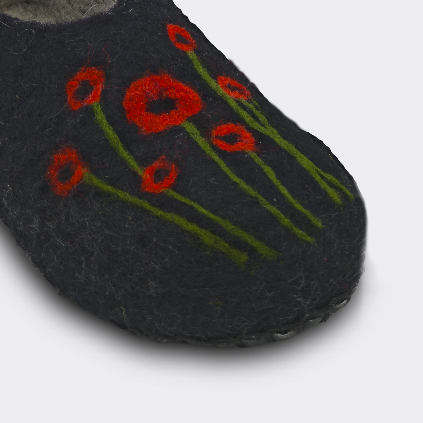 Vue en détail d'un chausson en feutre artisanal, noir avec coquelicots