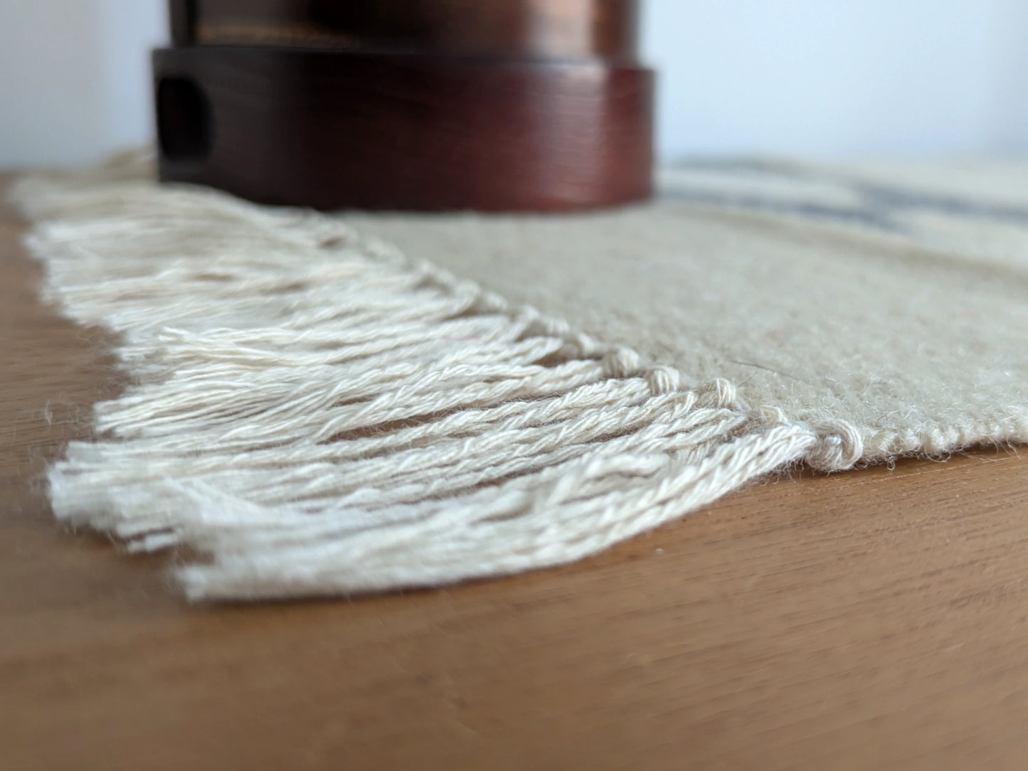 Détail des franges d’un kilim crème et gris, tissé à plat en laine