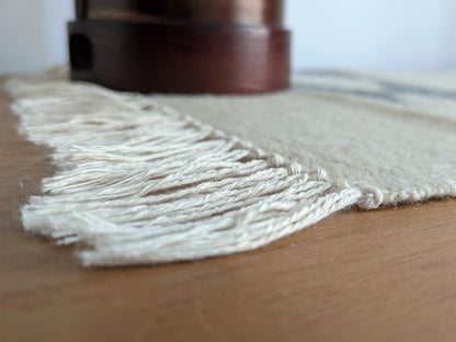Détail des franges d’un kilim crème et gris, tissé à plat en laine