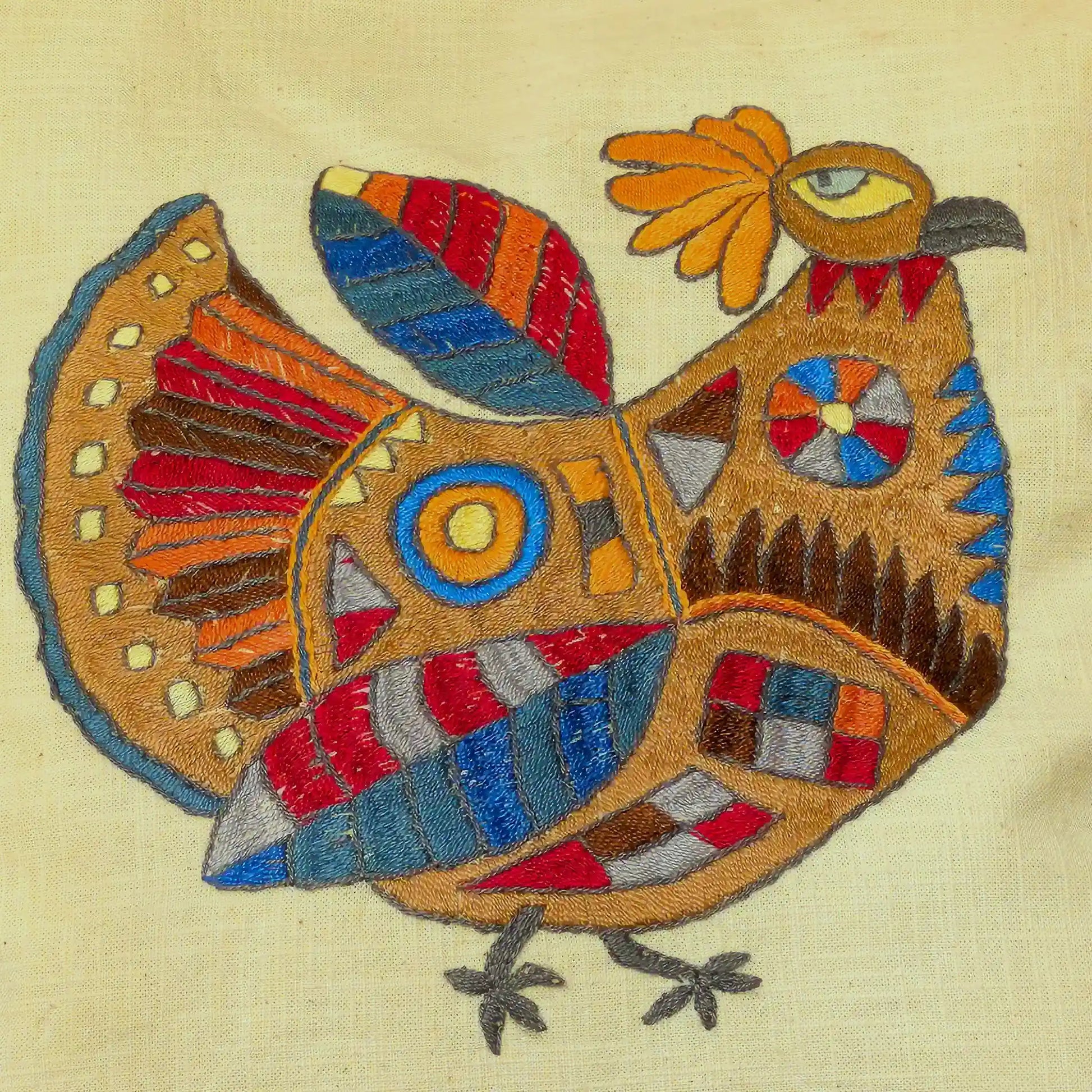 Détail de la broderie de poule stylisée en couleurs vives sur housse de coussins
