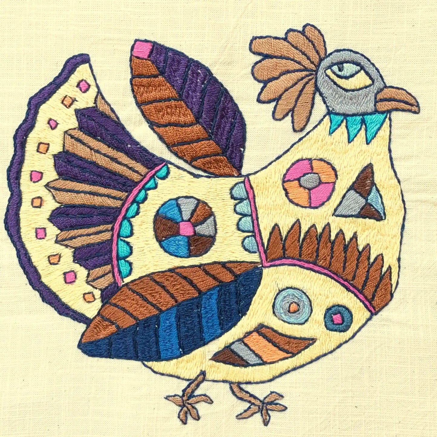 Détail de la broderie de poule stylisée en couleurs vives sur housse de coussins, modèle 6