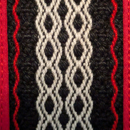 Détail de la trame centrale tissée de la trousse rouge.