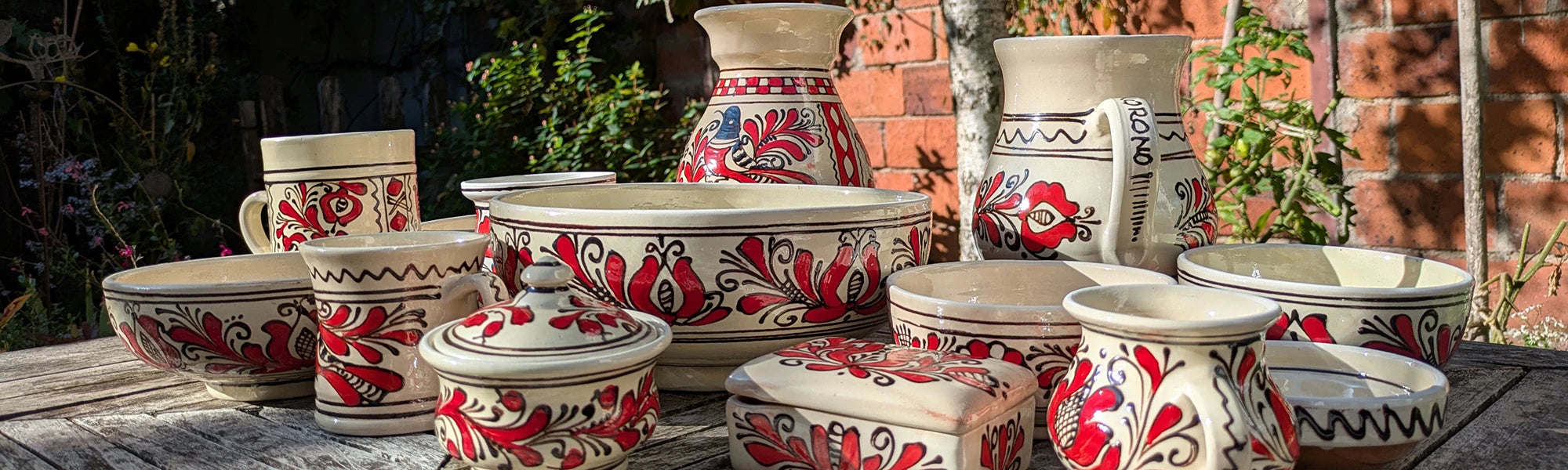 Vue d'ensemble de tout un assortiment de céramiques de Corund, en provenance de Roumanie. Bols, carafes, tasses, mugs, sucriers, saladier, vases.