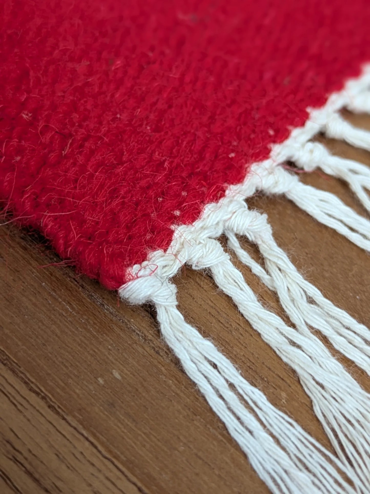 Franges de kilim rouge en laine, détail du bord tissé main