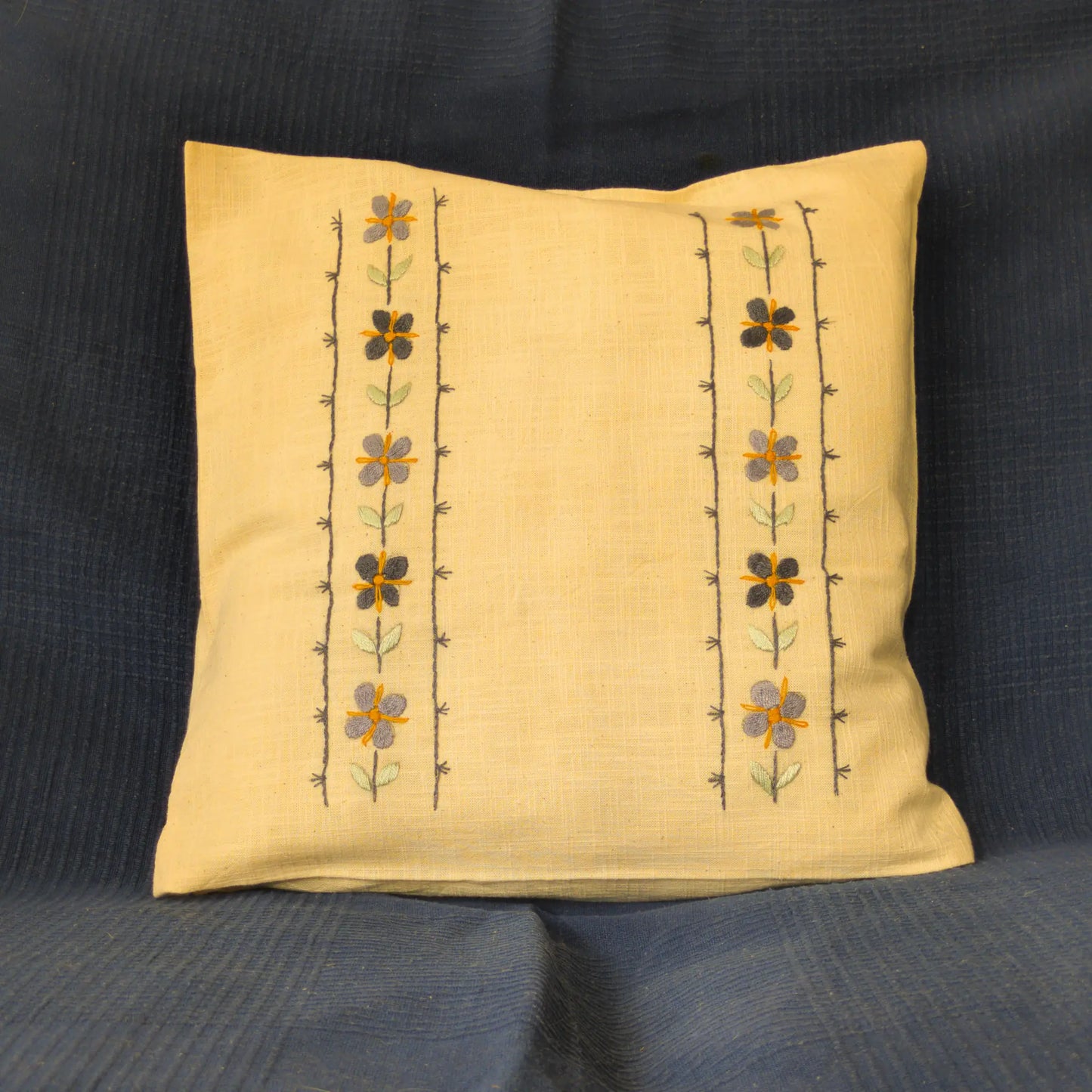 Housse de coussin en lin lavé brodée de fleurs verticales. Le motif floral se répète en colonnes fines. Un coussin en lin artisanal.