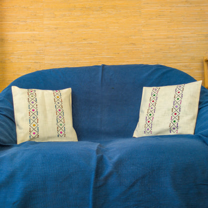 Coussins avec housses en lin brodées de motifs traditionnels serbes. Posés sur un canapé.