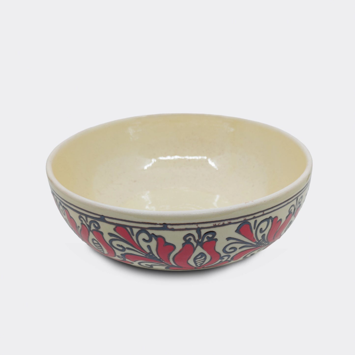 Jatte artisanale en faïence de Corund au décor floral rouge. Les motifs traditionnels székely sont peints à la main sur émail crème. Un bol de service utilisé pour fruits, soupe ou autres mets.