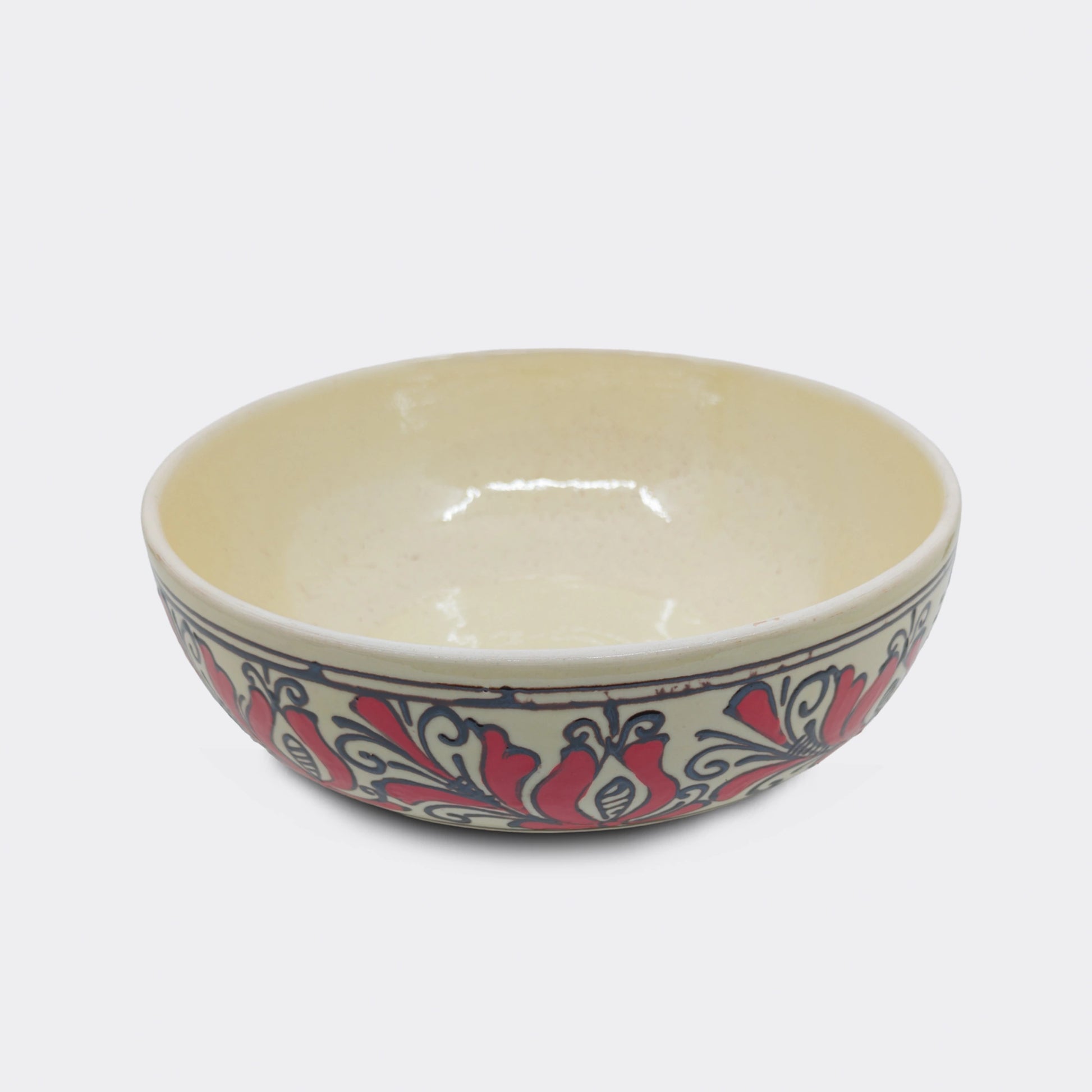 Jatte artisanale en faïence de Corund au décor floral rouge. Les motifs traditionnels székely sont peints à la main sur émail crème. Un bol de service utilisé pour fruits, soupe ou autres mets.