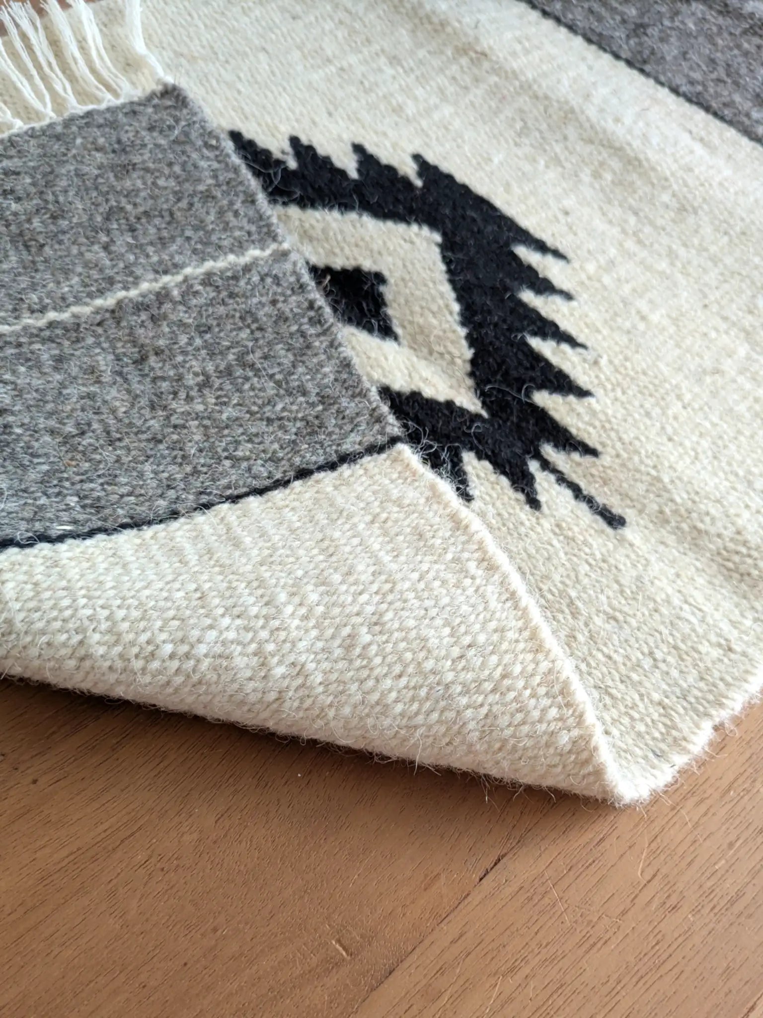 Kilim réversible crème et gris, replié pour montrer un tissage identique à l’endroit et à l’envers