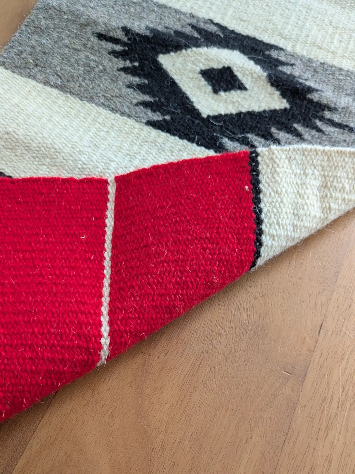 Kilim réversible légèrement replié, montrant un tissage identique à l’endroit et à l’envers
