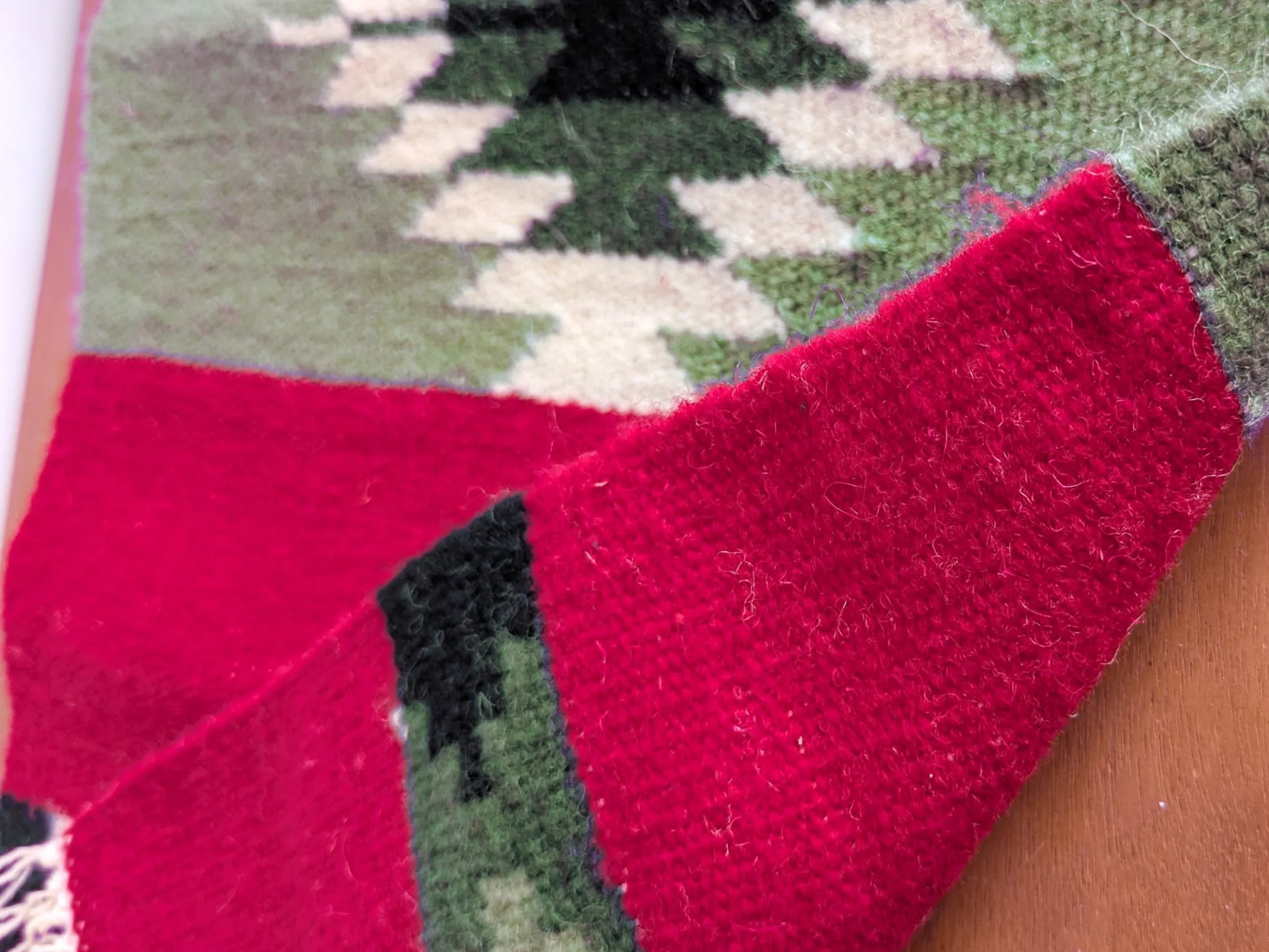 Kilim réversible rouge et vert olive, replié pour montrer l’endroit et l’envers du tissage