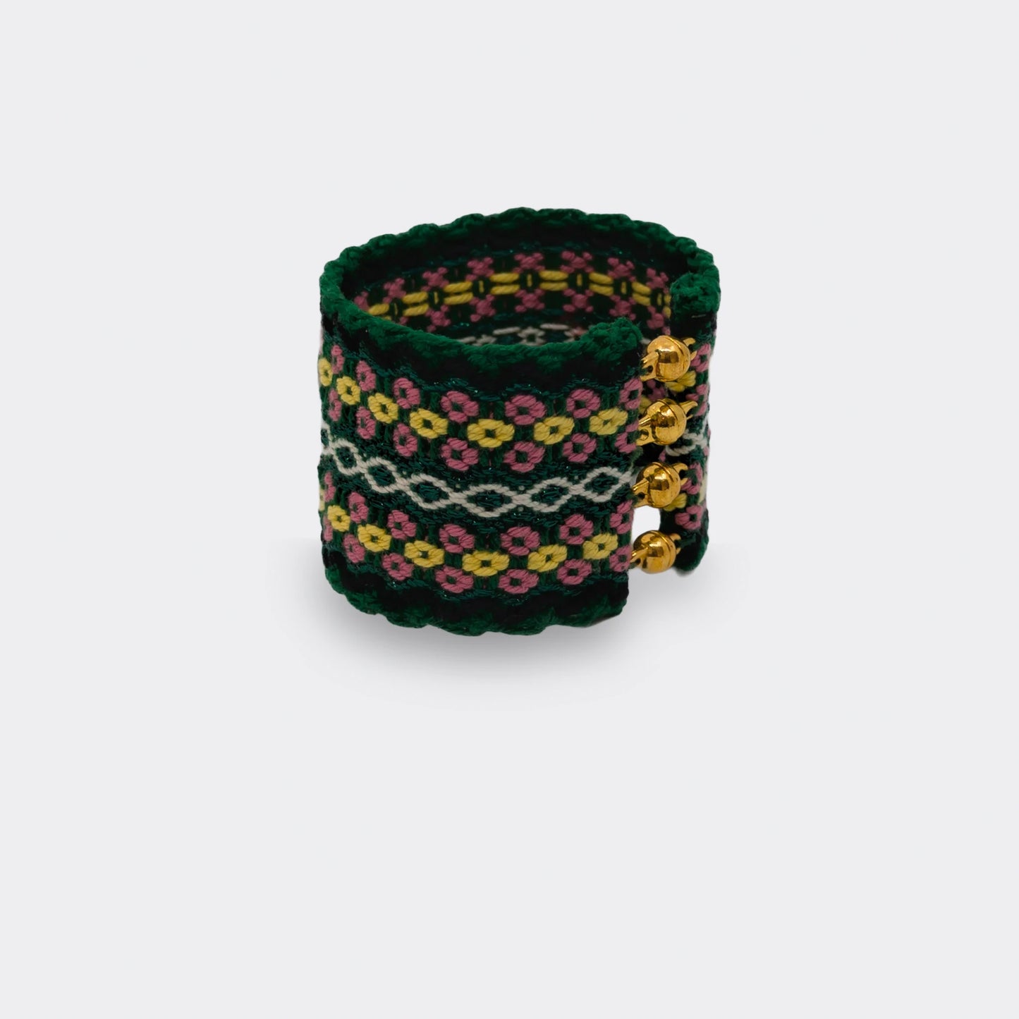 Bracelet tissé vert , jaune et rose en coton, à motifs inspirés du folklore balkanique, vue de face.