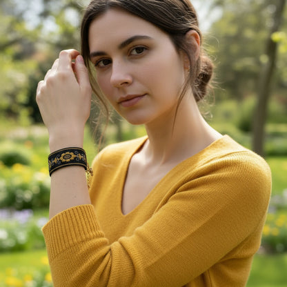 Bracelet brodé noir et doré en coton, décoré d’un motif floral lumineux réalisé avec trois points traditionnels. Artisanat serbe inspiré du zlatovez