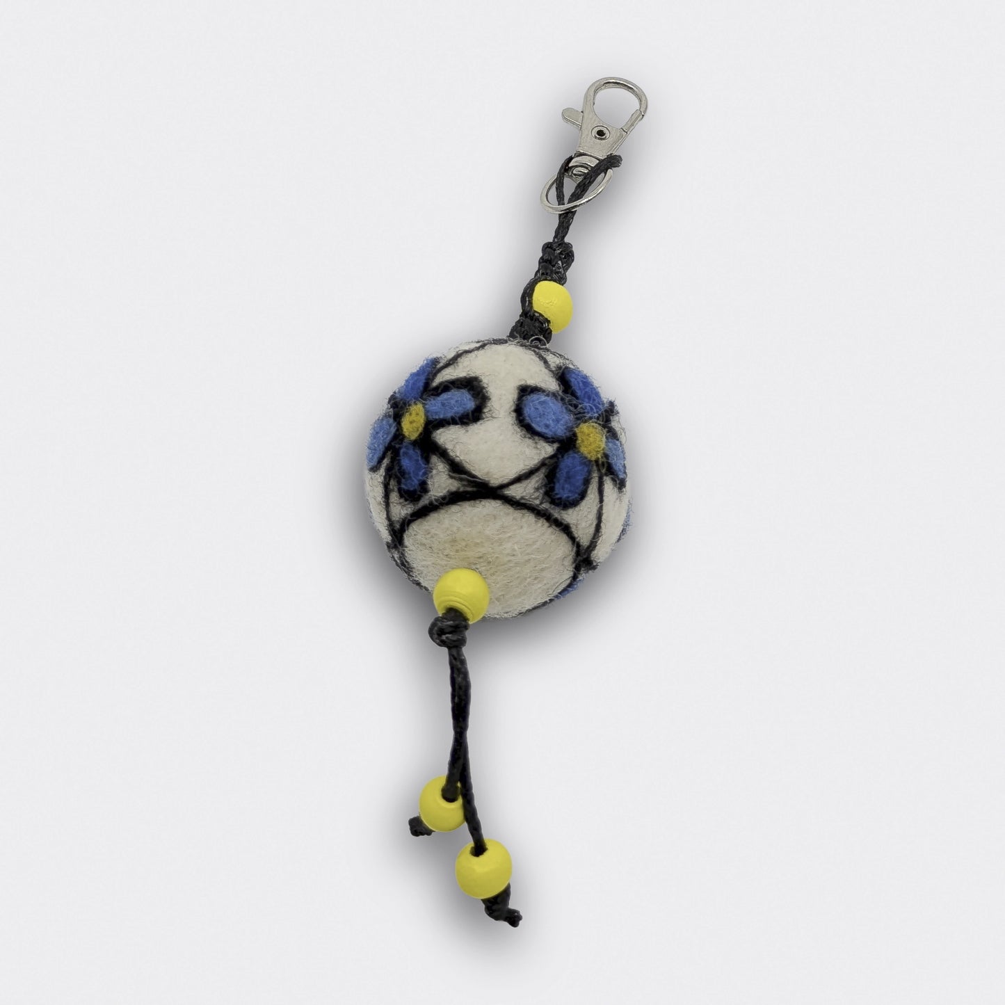 Breloque Milena en feutre clair avec des fleurs bleues à coeur jaune