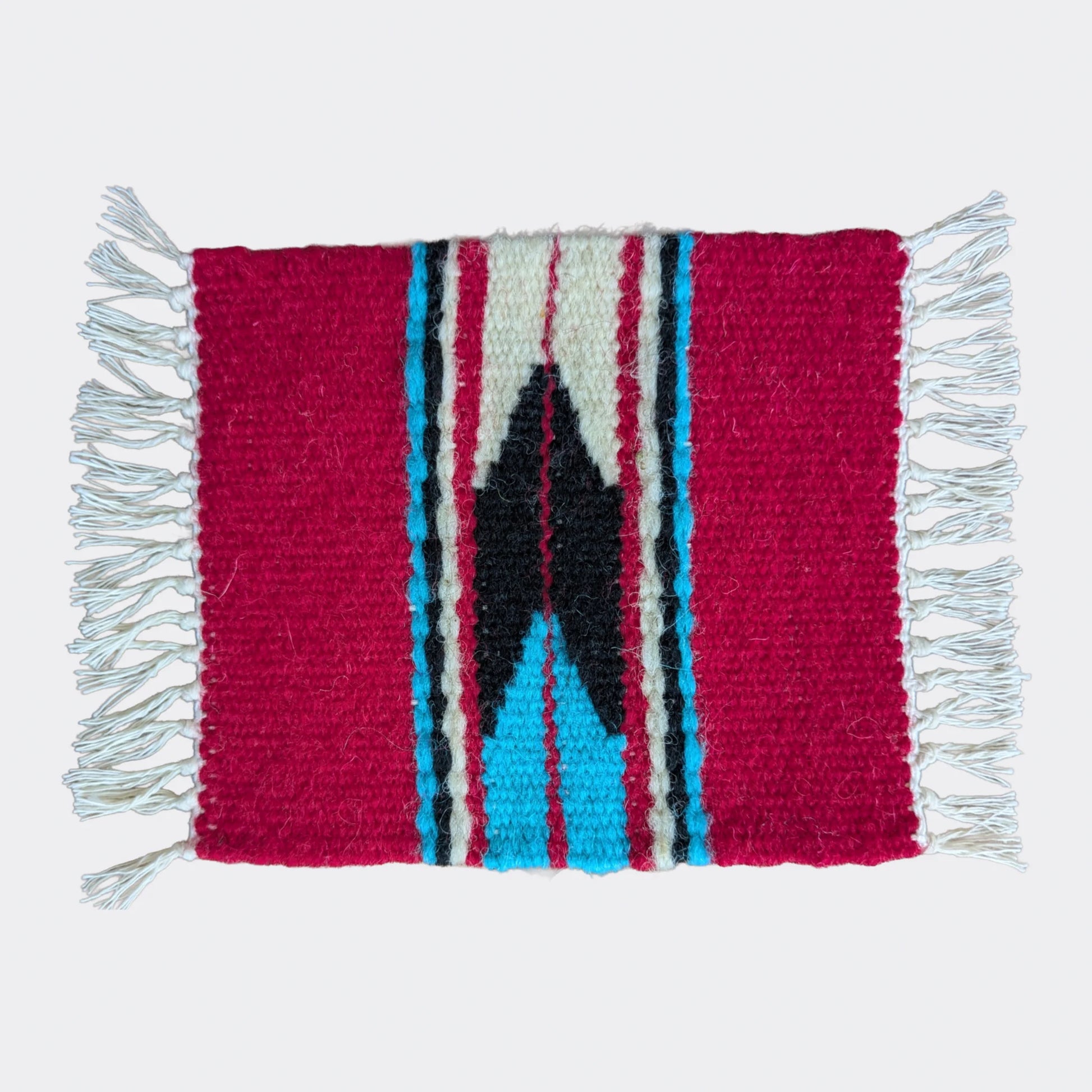 Dessous de verre en laine tissé au Monténégro. Formes géométriques contrastées dans des tons rouges et bleus.