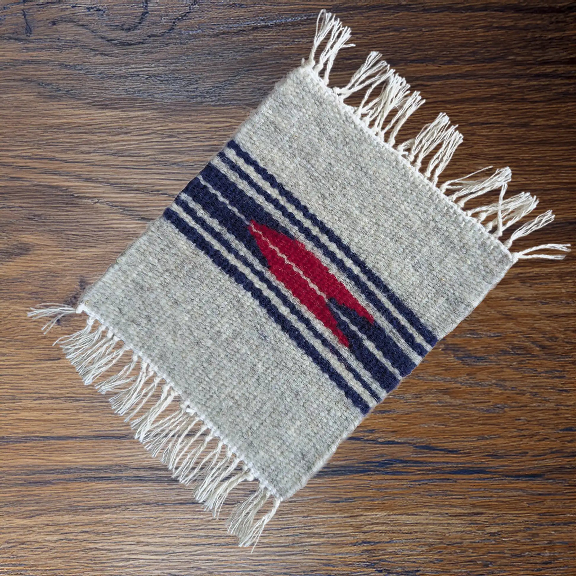 Mini tapis monténégrin de couleur grise pouvant faire office de dessous de verre. Motif inspiré des motifs traditionnels.