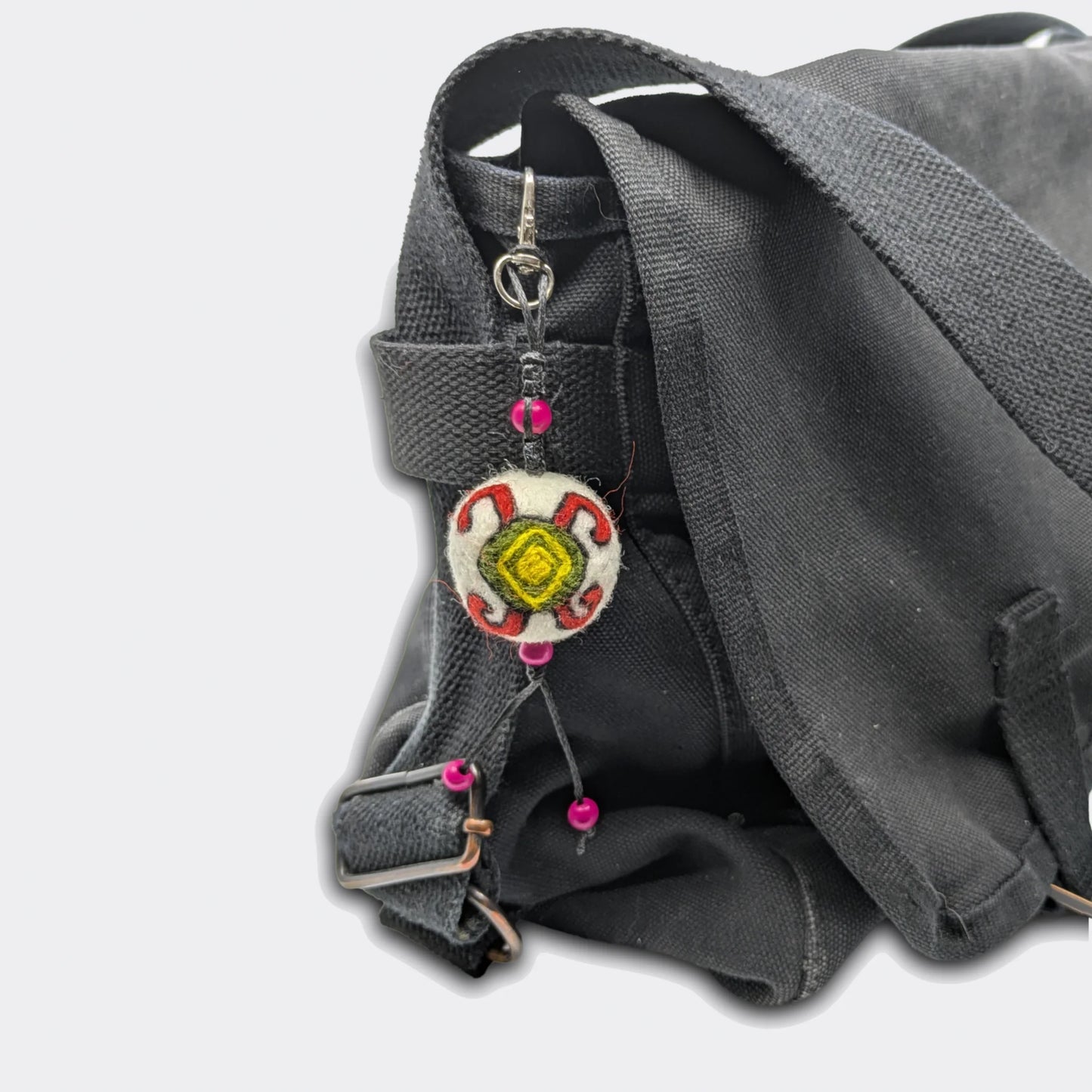 Vue de la breloque Mirna en feutre avec motif tortue rouge, jaune et verte traditionnelle