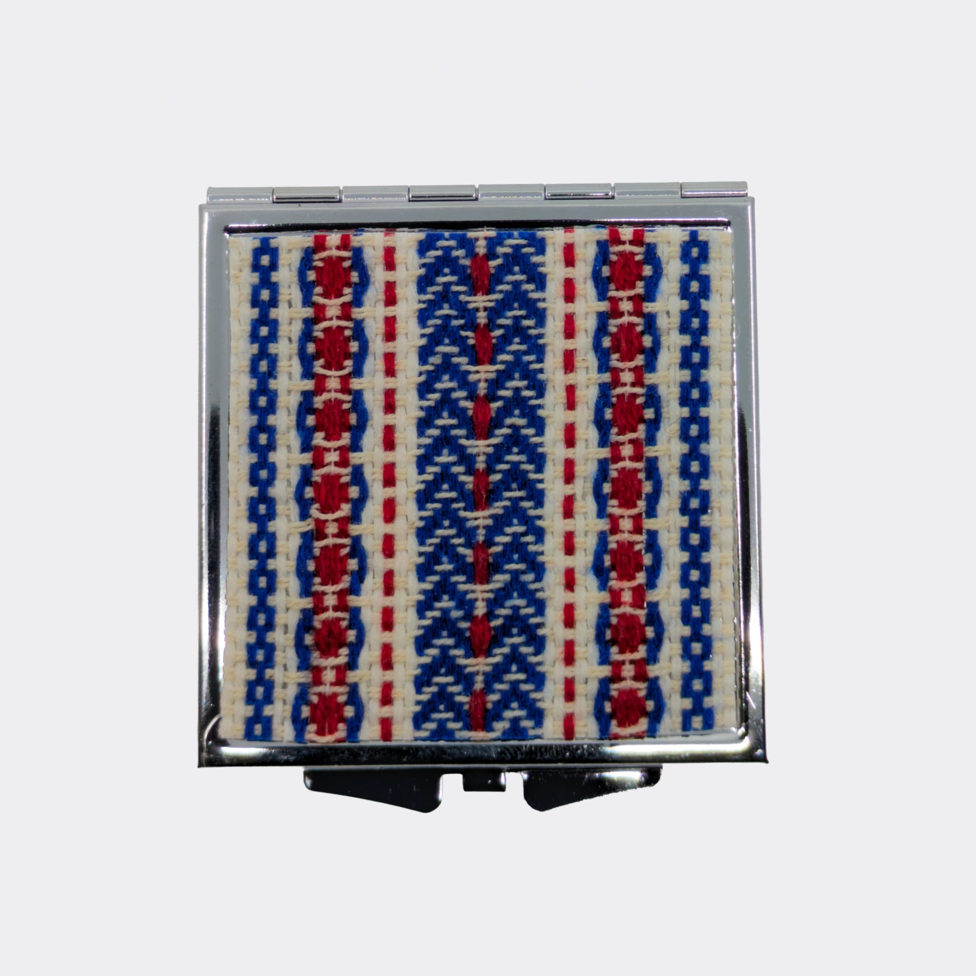 Détail du décore textile tissé à la main et collé sur le miroir de poche.