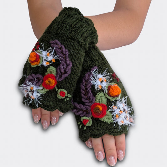 Mitaines vert olive portées mains croisées, tricotées main avec fleurs crochetées en relief et feuillage brodé.