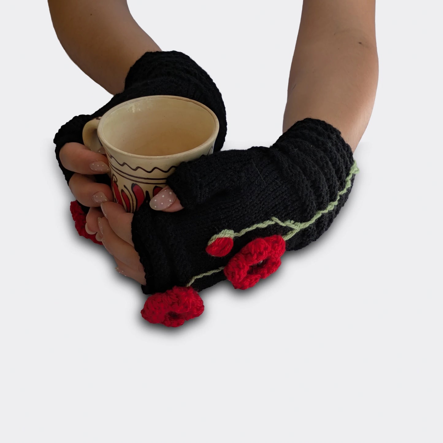 Mitaines noires tenant une tasse, décorées de coquelicots rouges en relief, tiges brodées et bord côtelé.
