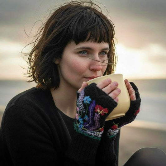 Paire de mitaines artisanales noires, motifs floraux colorés, brodés main, finition festonnée.