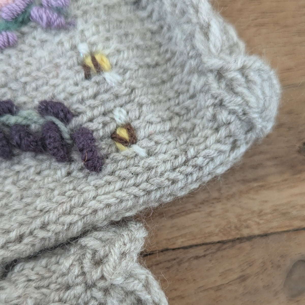 Mitaines femmes, artisanales, fleurie, avec feston supérieur près duquel sont brodées deux petites abeilles.