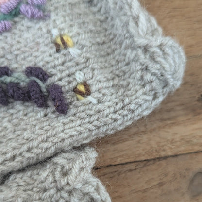 Mitaines femmes, artisanales, fleurie, avec feston supérieur près duquel sont brodées deux petites abeilles.