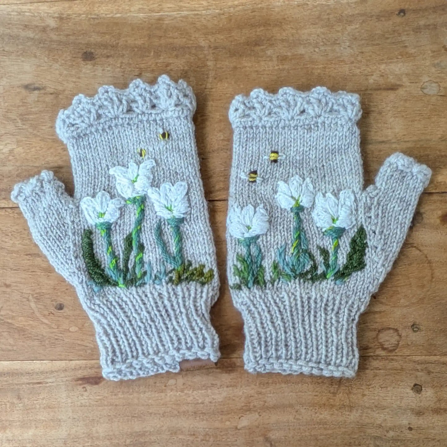 Mitaines gris perle tricotées main avec fleurs blanches de crocus et petites abeilles brodées.