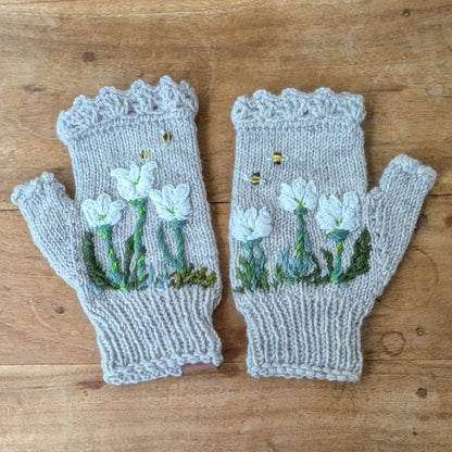 Mitaines gris perle tricotées main avec fleurs blanches de crocus et petites abeilles brodées.