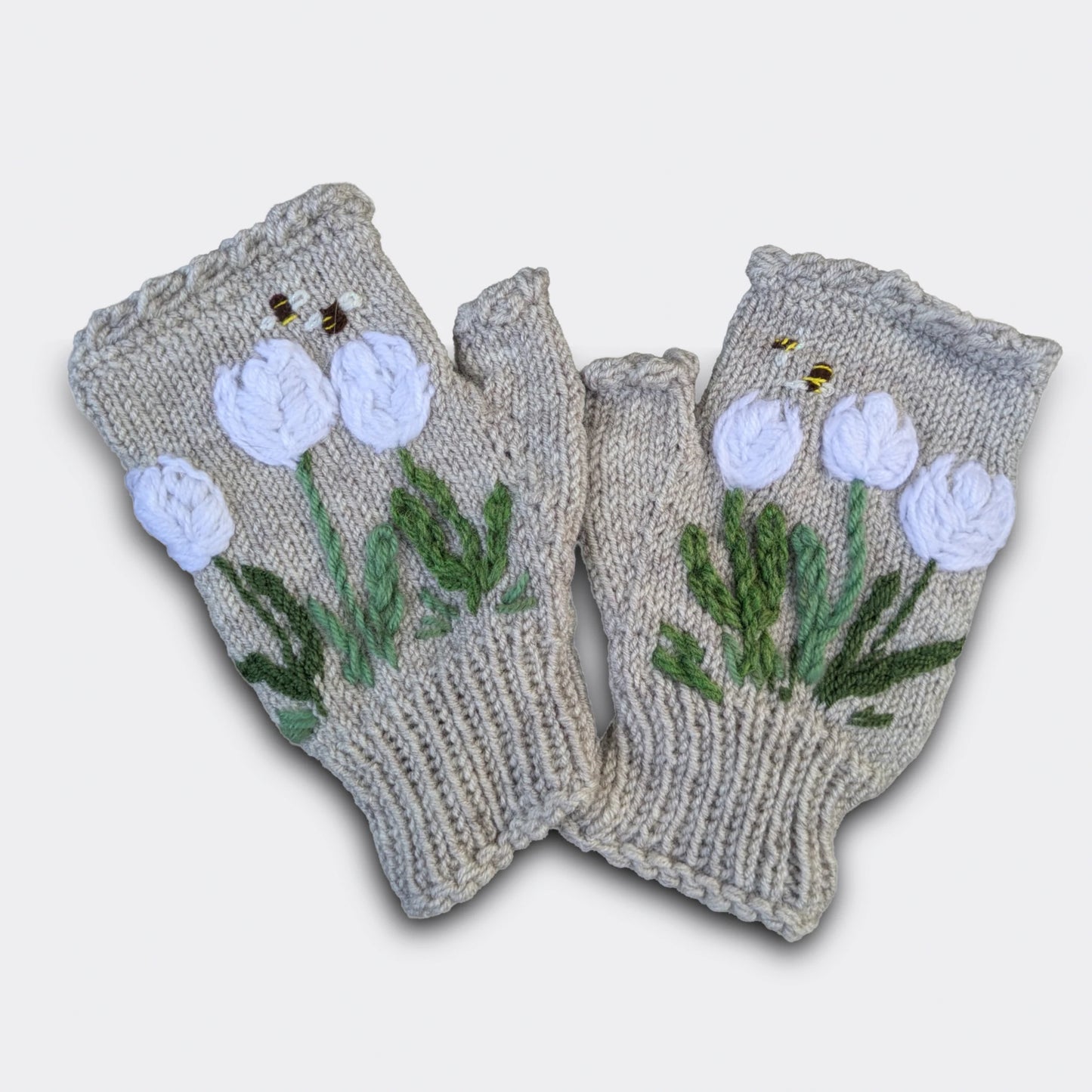 Mitaines tricotées main gris perle avec fleurs de crocus blancs crochetées et brodées.