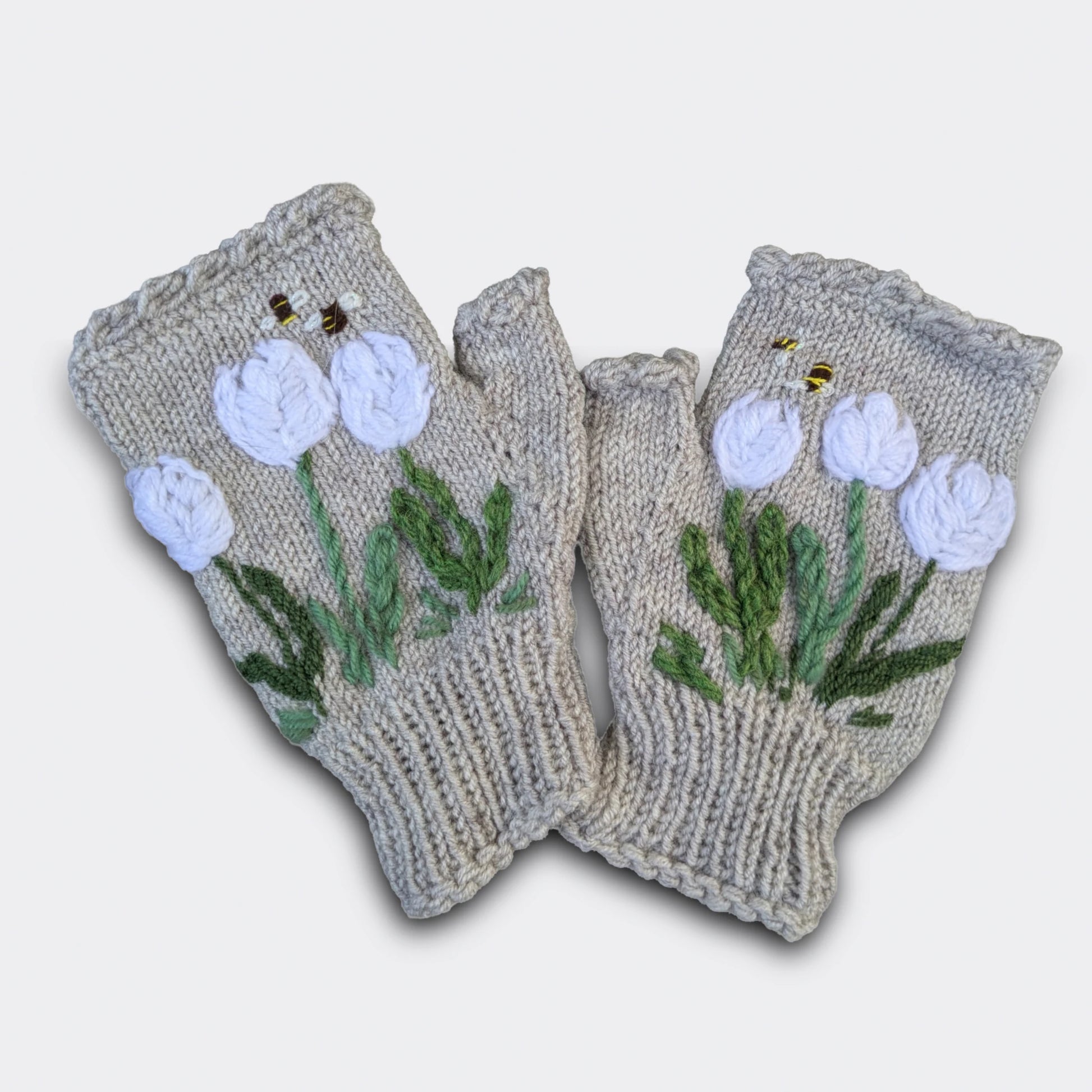 Mitaines tricotées main gris perle avec fleurs de crocus blancs crochetées et brodées.