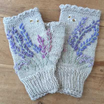 Mitaines gris perle posées à plat, avec bouquet de lavandes mauves et parme brodées sur la maille.