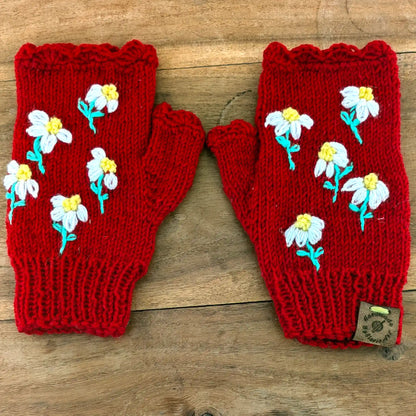 Paire de mitaines rouges avec des fleurettes aux pétales blancs et au coeur jaune disposées deci delà 