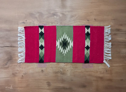 Vue d’ensemble d’un tapis artisanal rouge et vert du Montenegro. Les bandes verticales et le motif central offrent une esthétique traditionnelle.