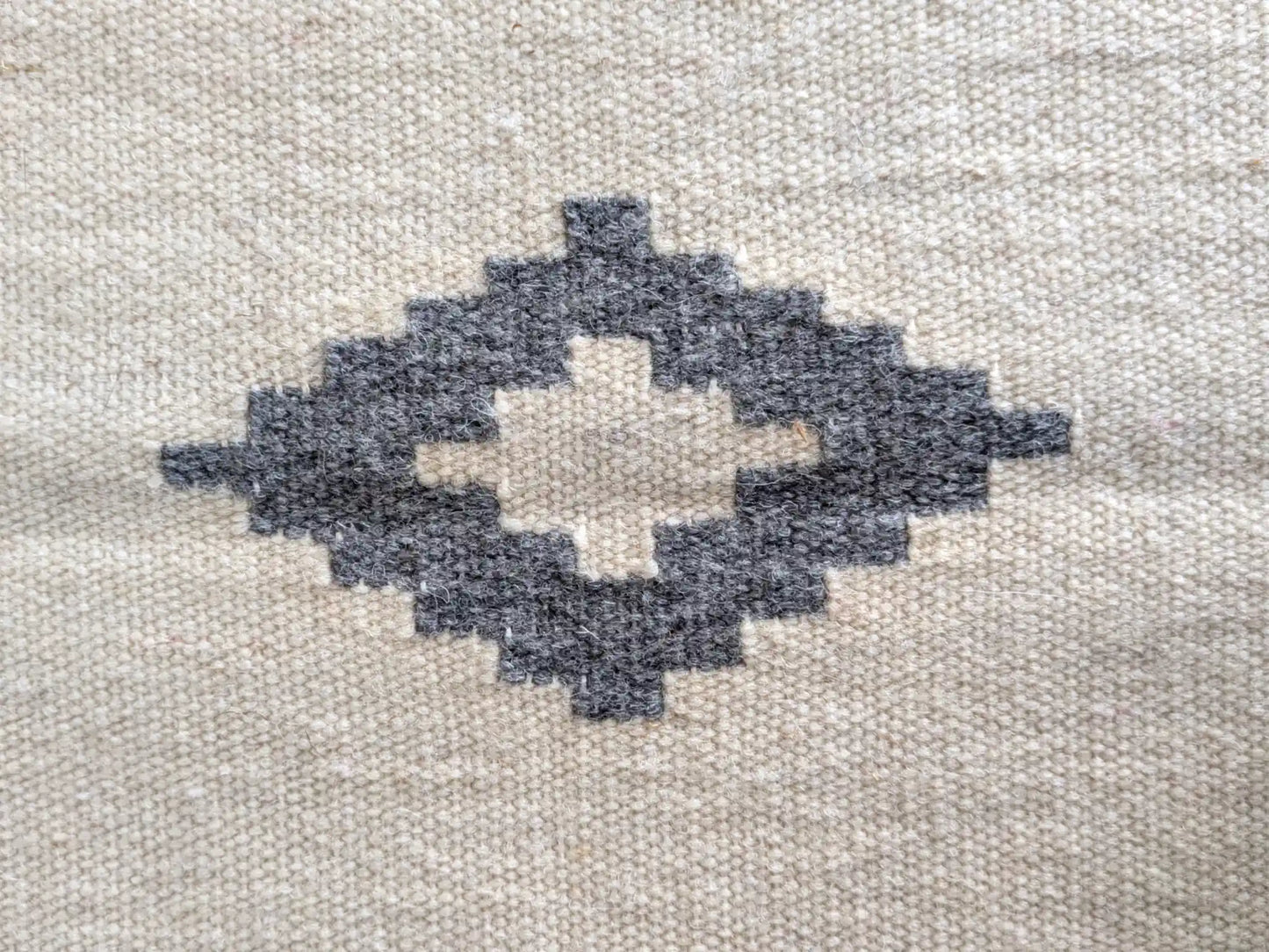 Motif kilim gris sur fond crème, détail du losange central tissé à la main