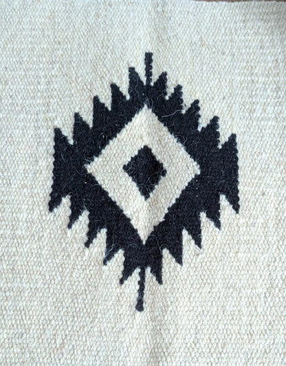 Motif kilim noir sur fond crème, détail du losange central tissé à la main