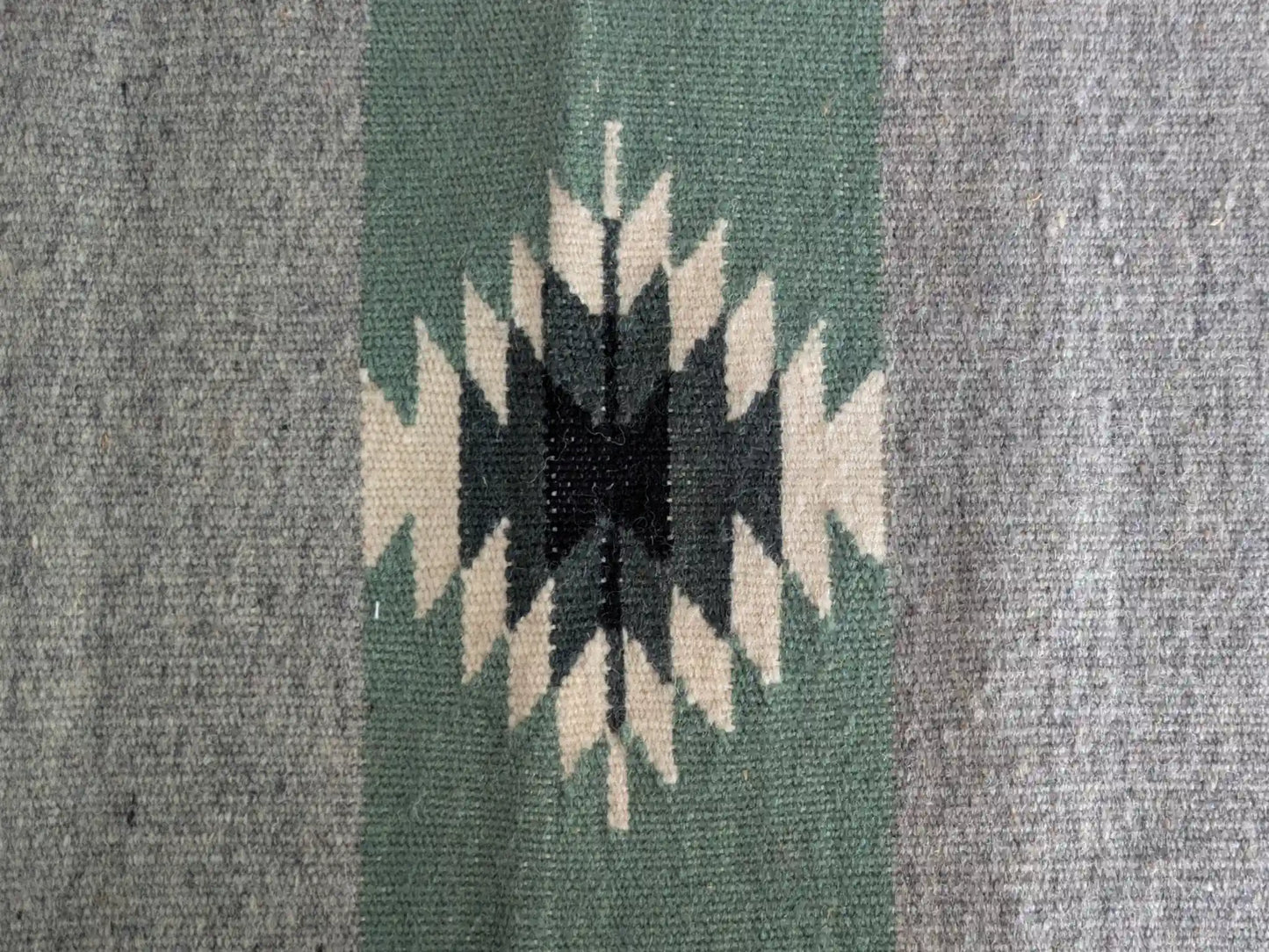 Motif kilim géométrique noir et écru sur bandes vert olive et grises