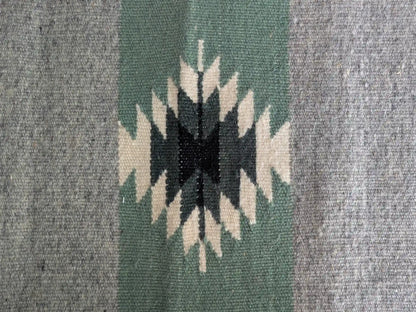 Motif kilim géométrique noir et écru sur bandes vert olive et grises