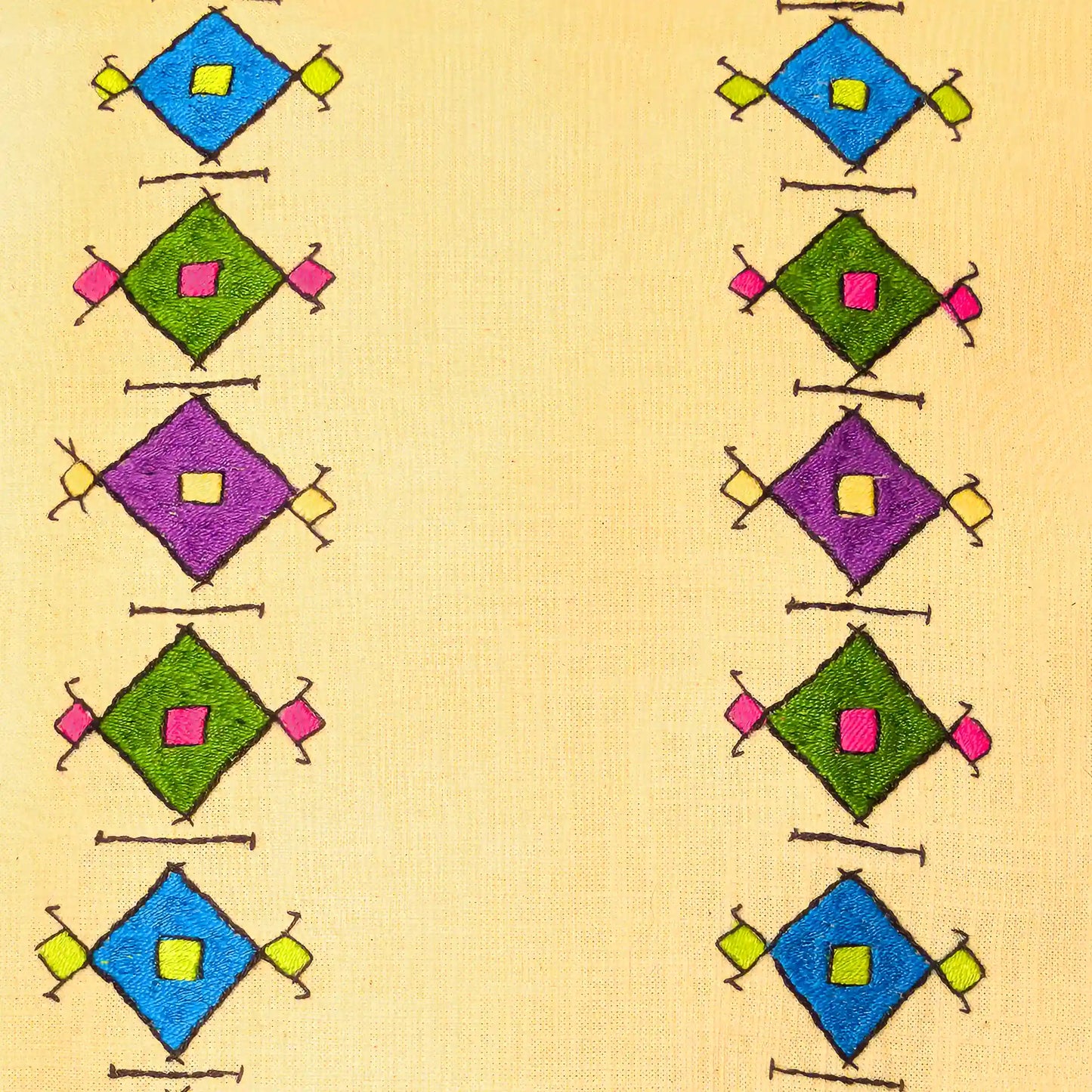 Détail des motifs en losange brodés main de style serbe sur une housse de coussin en lin.