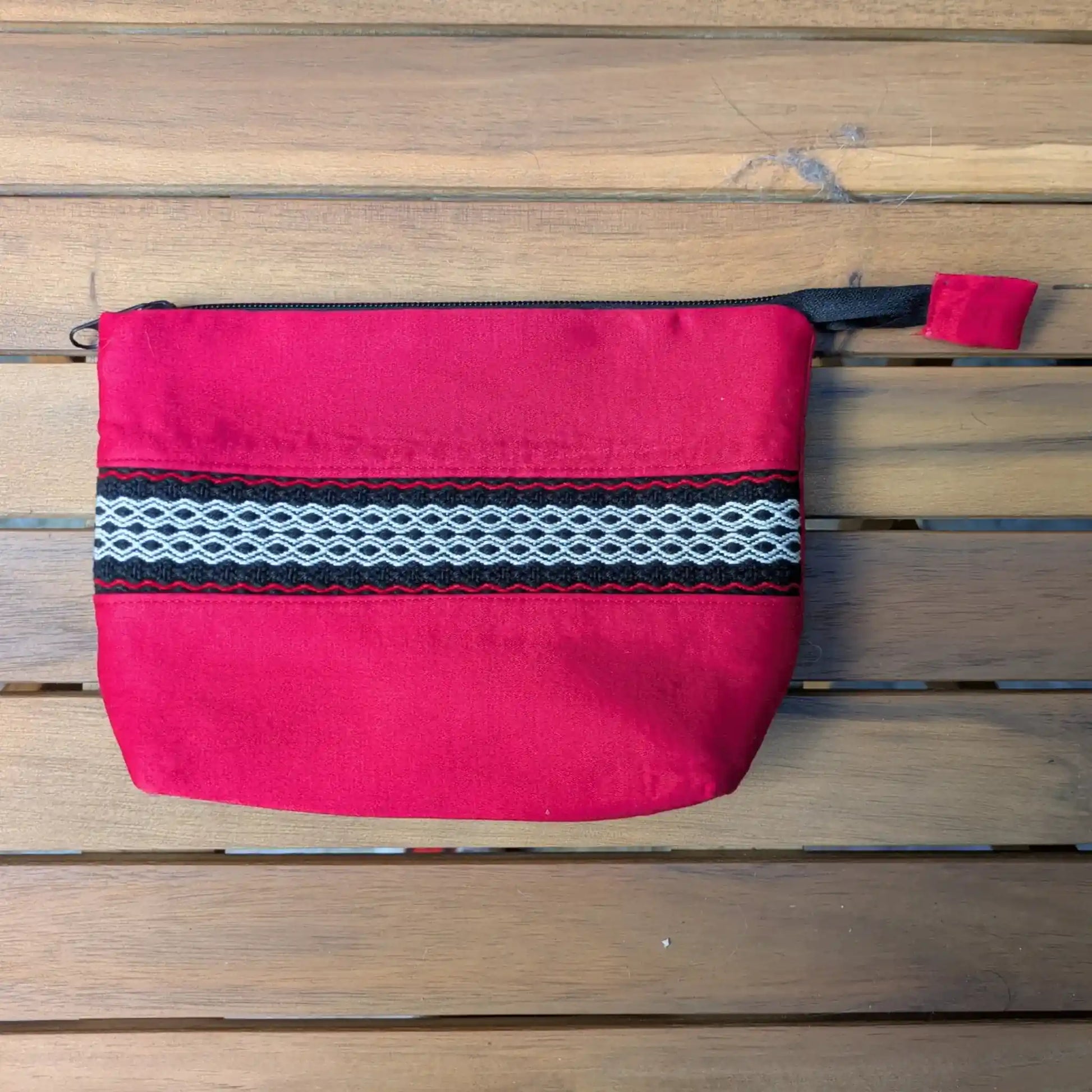 Nécessaire de toilette rouge cousu main, avec bande centrale tissée noire, blanche et rouge.