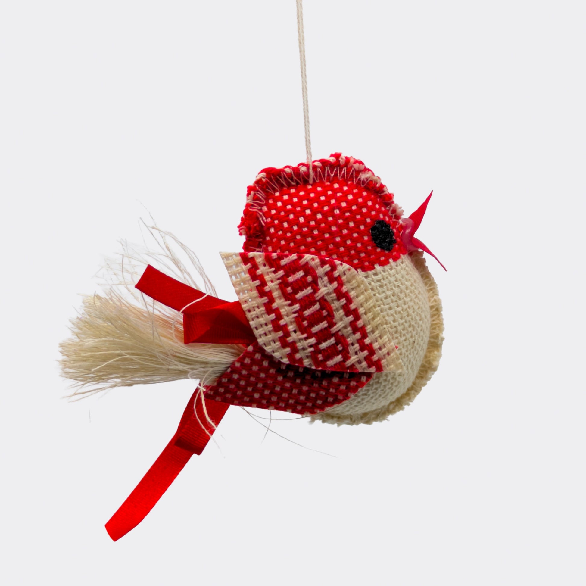 Petit oiseau rouge en tissu, suspendu à un fil et rembourré. La tête rouge et les motifs tissés soulignent l’artisanat. Une décoration à suspendre douce et légère.