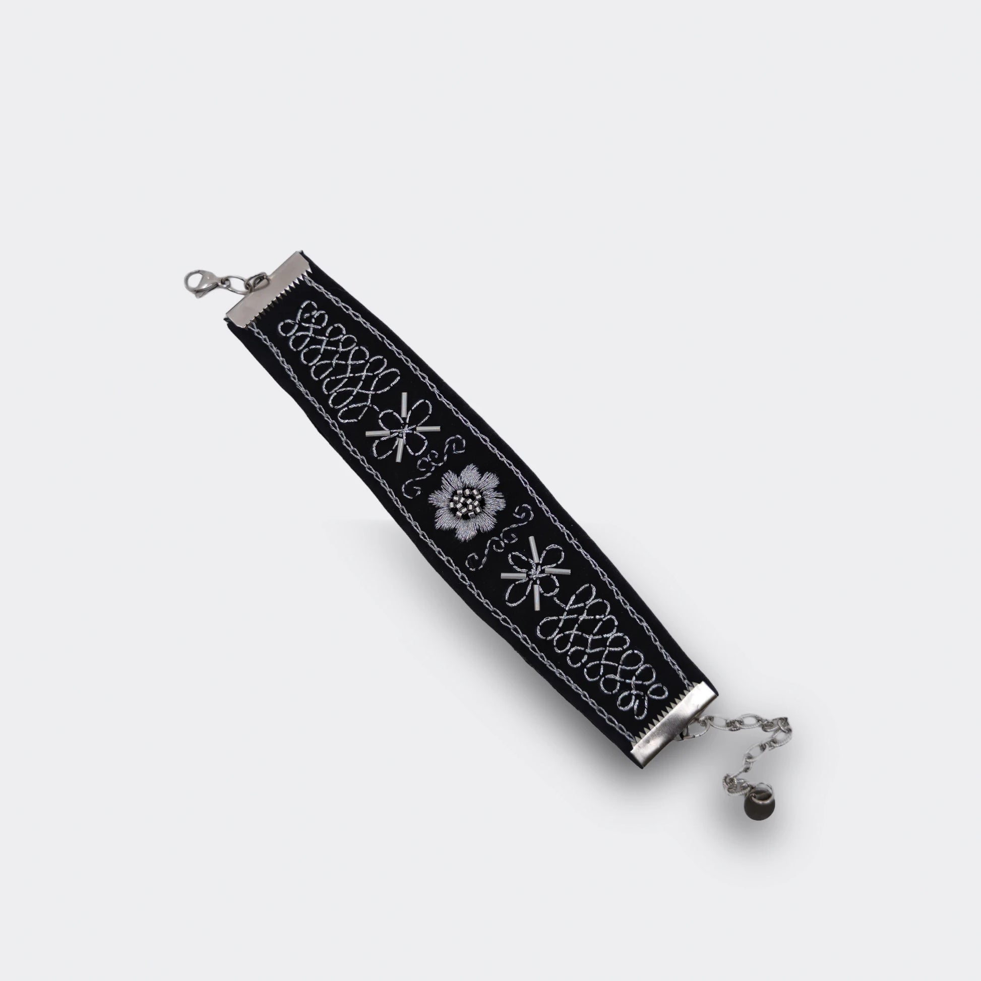 Bracelet artisanal brodé noir avec décor argenté, mélange de point de chaînette et de point plein. Style balkanique moderne et traditionnel, vue du haut