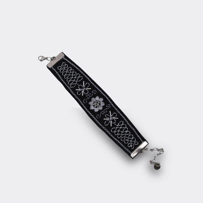 Bracelet artisanal brodé noir avec décor argenté, mélange de point de chaînette et de point plein. Style balkanique moderne et traditionnel, vue du haut