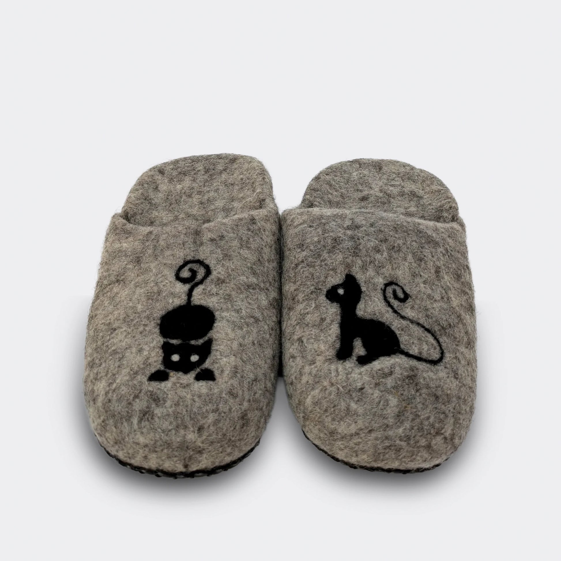 Pantoufle artisanale en laine grise, motif de chat noir minimaliste, confectionnée en Serbie avec feutre traditionnel. Vue de face.