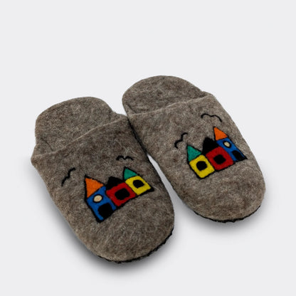 Pantoufle en feutre grise faite main en Serbie, ornée de trois petites maisons multicolores, vue de biais.