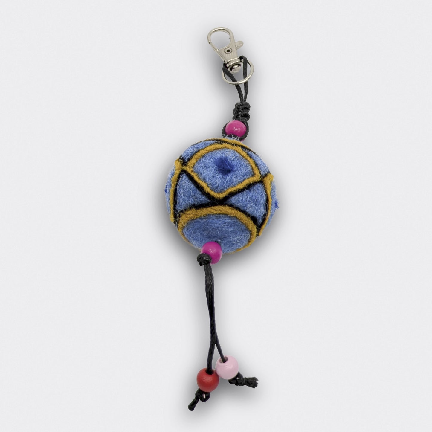 Breloque de sac artisanale Borka en feutre bleu clair avec formes géométriques et petites perles le long d'un cordon