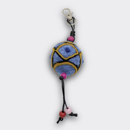 Breloque de sac artisanale Borka en feutre bleu clair avec formes géométriques et petites perles le long d'un cordon